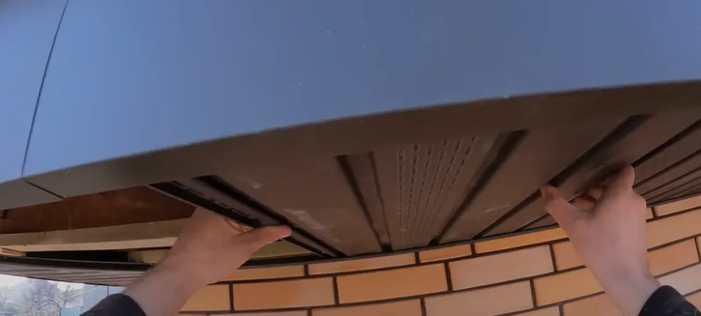 Сплошные софиты Bryza в цвете “темно-коричневый”, имитирующие дерево, в сочетании с темно-коричневой металлочерепицей. Сплошные софиты Bryza в цвете “темно-коричневый”, имитирующие дерево, в сочетании с темно-коричневой металлочерепицей.